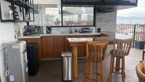 Una cocina con encimera de madera, un lavabo y vistas a la ciudad a través de un ventanal grande.