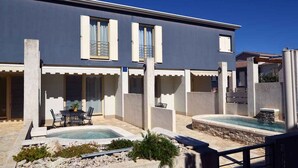 A modern house with a pool, outdoor seating, and a covered patio area. - Villa with pool near the beach (Banjole)