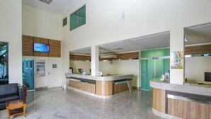 Un área de recepción con mostrador, asientos y televisión.