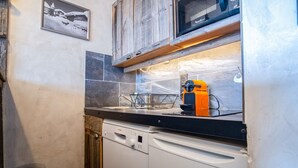 A kitchen with a dishwasher, a microwave, and a sink. - Appartement du Rif - Welkeys (Huez)