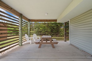 Relax in this outdoor seating area with a picnic table and Adirondack chairs.