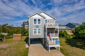 A two-story house with a balcony, a small deck, and a sign indicating Coastal Carolina Vacations. - Salada Sea Breeze: 5 min. walk to the beach, oceanside (Nags Head)