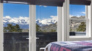 A bedroom with a large window offering a mountain view. - Spectacular Views of Long's Peak- 10 min to town-3 full bath plus 2 half bath (Estes Park)