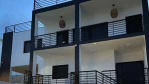Ein modernes Mehrstöckhaus mit Balkonen und einem gut beleuchteten Eingangsbereich.