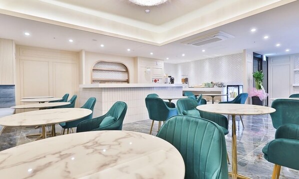 A modern hotel lobby with round marble tables and teal upholstered chairs. - Riverside in February Gyeongsangbuk-do (Gyeongsan)