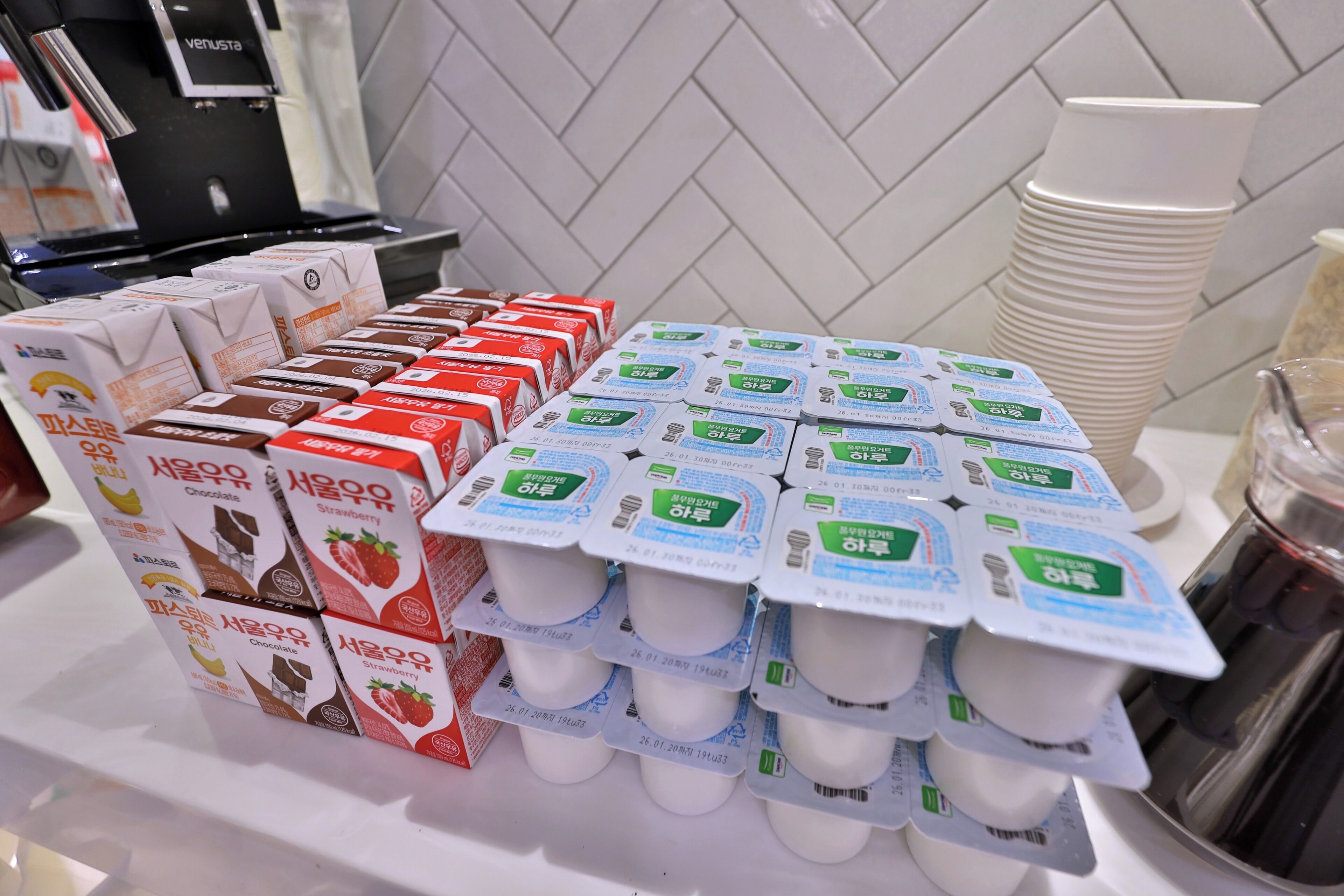 A display of packaged beverages, including chocolate and strawberry-flavored drinks, and yogurt cups.