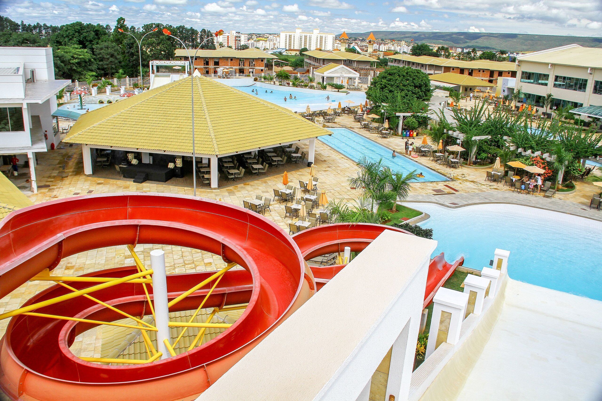 A water park with a large pool, slides, and outdoor seating areas.