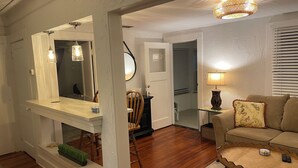Un salon doté d’un plancher en bois, d’un canapé, d’une table basse et d’un coin repas avec une table et des chaises.