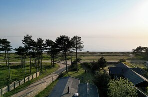 A rural landscape with a road, trees, and houses. - Holiday home on the beach with panoramic view (Store Fuglede)