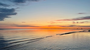 Una spiaggia con acque calme e un tramonto.
