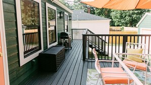 A deck with outdoor furniture, a grill, and a covered area with an umbrella.