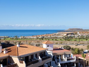 A coastal resort with multiple-story buildings, balconies, and a view of the sea.