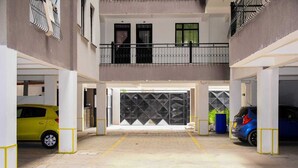A multi-level parking garage with yellow and blue cars parked. - 1 Bed Flat Sleeps 2 with On-Site Parking (Nairobi)