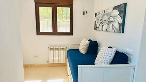 Une chambre à coucher comprenant un lit, un radiateur, une fenêtre et une œuvre d’art accrochée au mur.