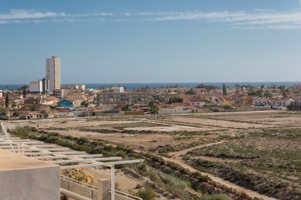 A coastal cityscape with residential buildings, a tall building, and a clear sky. - Holiday Apartment "Clayma" with Sea View, Shared Pool & Wi-Fi (Puerto de Mazarrón)
