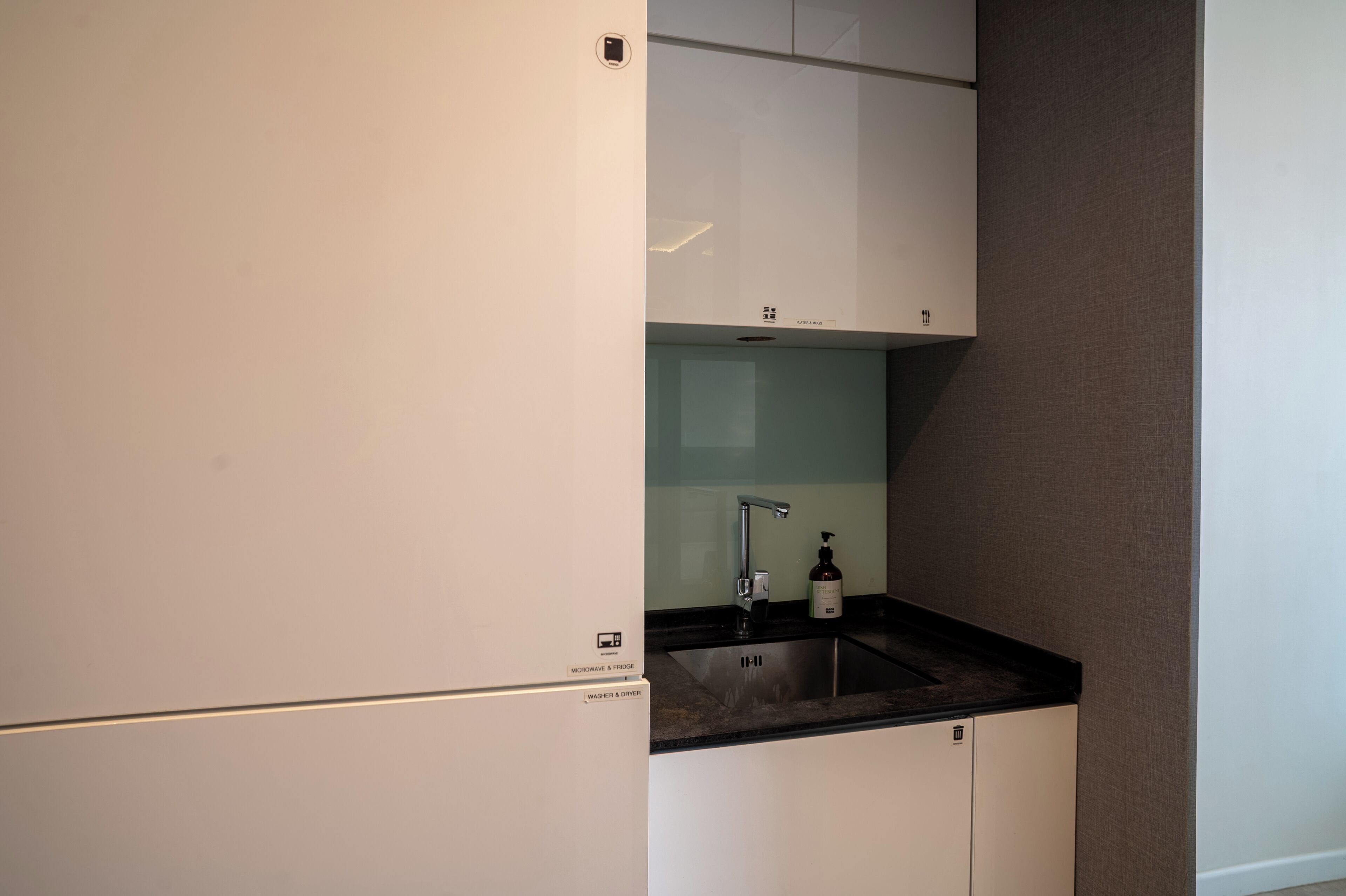 A compact kitchen with a built-in microwave, a sink, and a small countertop.