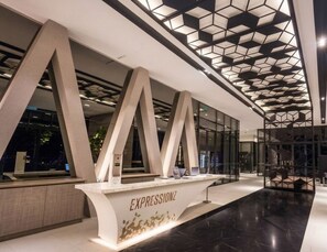 A reception desk with a modern design, geometric ceiling pattern, and a clean, contemporary lobby.