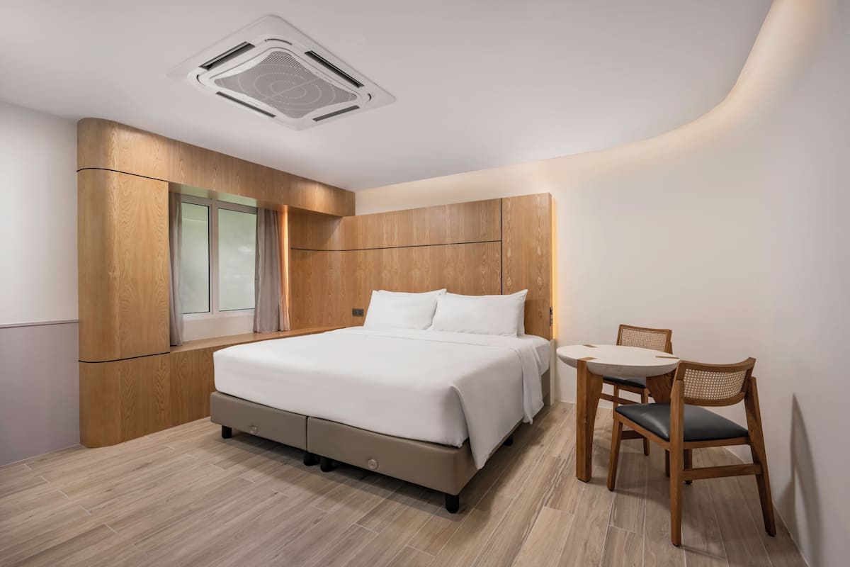 Une chambre à coucher moderne avec un lit, une petite table et une chaise.