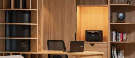 A modern office space with a curved desk, office chair, and a bookshelf.