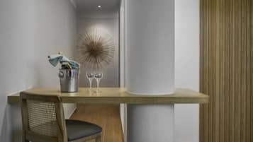 A modern dining area with a wooden table, a woven chair, and a decorative wall piece.