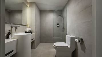 A modern bathroom with a toilet, sink, and shower.