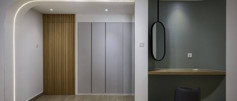 Un interior moderno con suelo de madera, una pared curva con una lámpara colgante y un armario empotrado.
