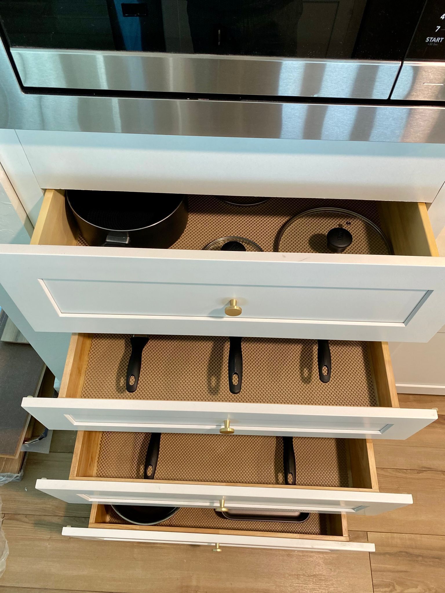 A kitchen drawer with multiple compartments, including a utensil holder and a spice rack.