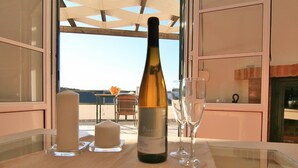 A table with a bottle of wine, two glasses, and a candle on a balcony overlooking a scenic view. - 'Studio Romantic Paradise 3' with Mountain View, Pool, Wi-Fi & Garden (Ronda)