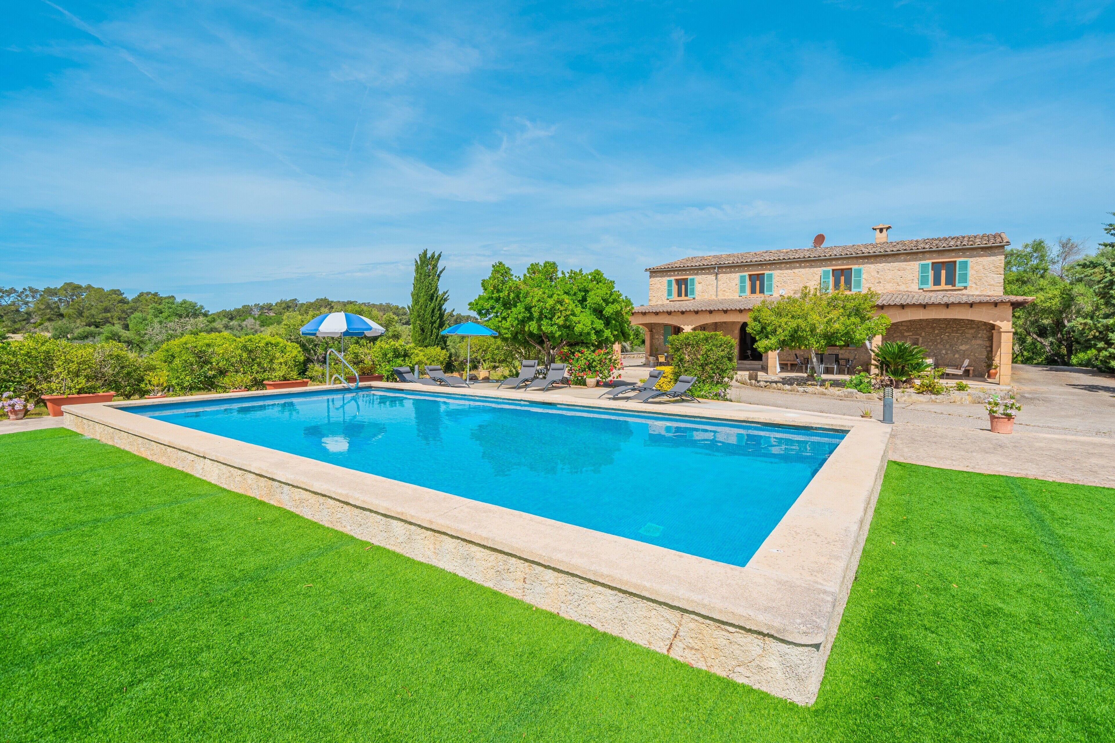 Una piscina con una casa al fondo.