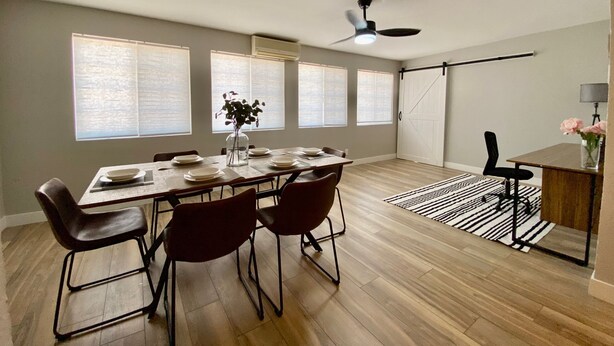 Un comedor espacioso con una mesa grande, sillas y un ventilador de techo.