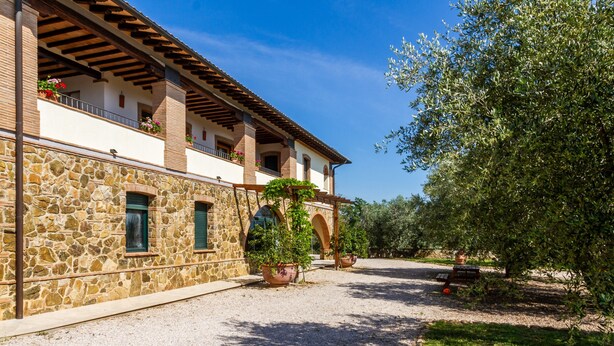 A stone building with balconies, a gravel path, and a tree. - Villa "Bouganville - Colleberto" with Sea View, Private Terrace & Wi-Fi (Follonica)
