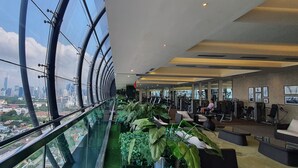 Ein Fitnessraum mit Glasboden, Trainingsgeräten und Blick auf die Stadt.