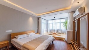 A modern hotel room with a large bed, a seating area with a view, and a wooden floor. - Suzhou Taihu Lakeside·Shanhu Yin·Holiday Homestay (Suzhou)