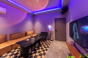 Um quarto com sofá, mesa, abajur e um quadro na parede.