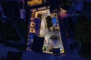 An aerial view of a hotel with a swimming pool, outdoor seating, and a well-lit entrance. - Suzhou Taihu Lakeside·Shanhu Yin·Holiday Homestay (Suzhou)