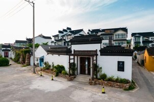 Un edificio de estilo tradicional con entrada de madera y un pequeño jardín.