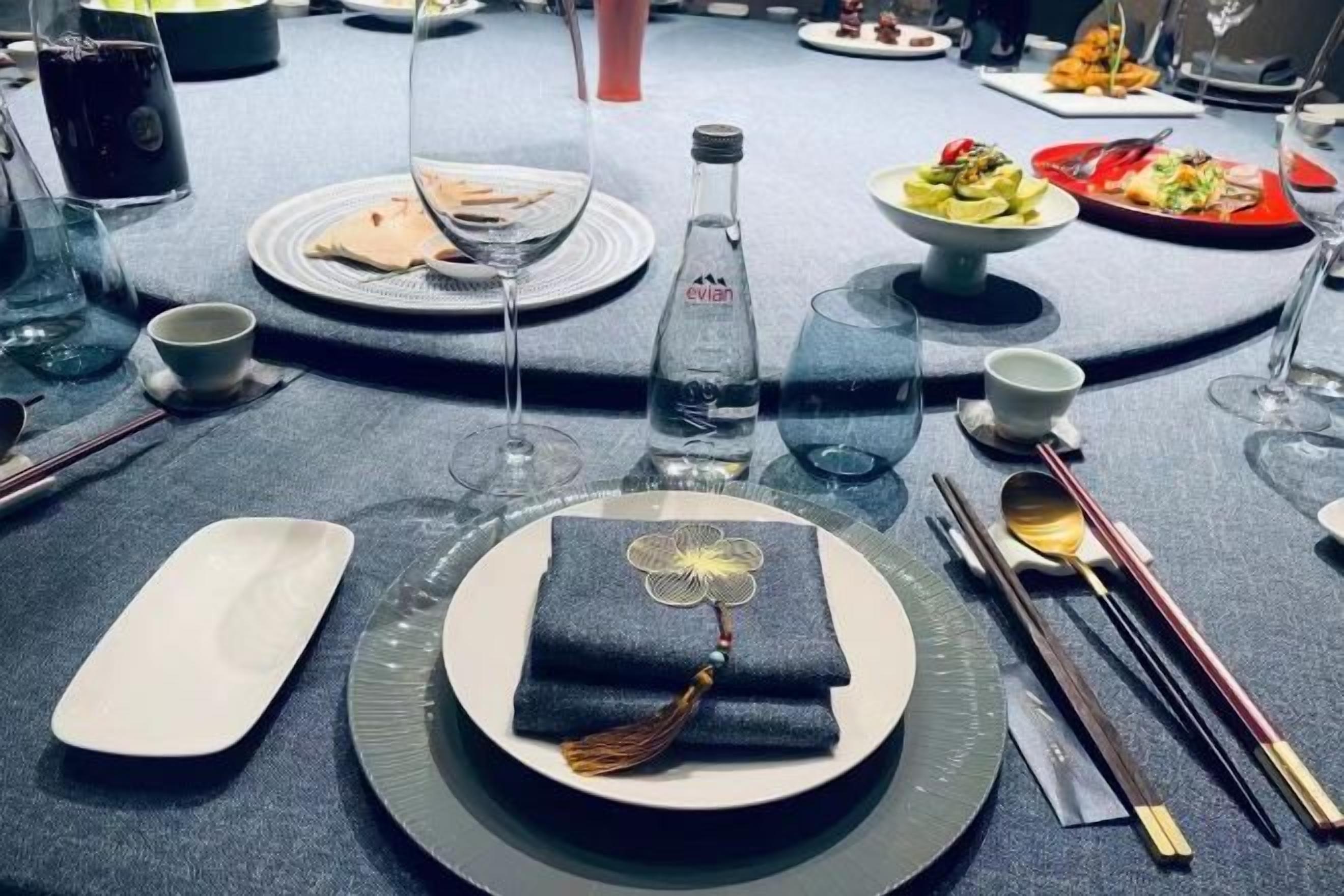 A table set with plates, bowls, chopsticks, and a bottle, suggesting a dining arrangement.