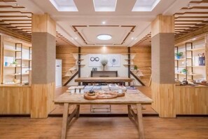 A modern interior with a central table, wooden shelving, and a ceiling with recessed lighting. - Suzhou Taihu Lakeside·Shanhu Yin·Holiday Homestay (Suzhou)