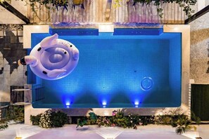 A large indoor swimming pool with a floating ring, surrounded by plants and a stone wall. - Suzhou Taihu Lakeside·Shanhu Yin·Holiday Homestay (Suzhou)