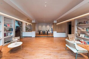 A spacious room with a wooden floor, a dining area, and built-in bookshelves. - Suzhou Taihu Lakeside·Shanhu Yin·Holiday Homestay (Suzhou)