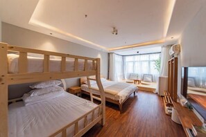 Une chambre avec des lits superposés, un bureau, une chaise et une fenêtre avec des rideaux.
