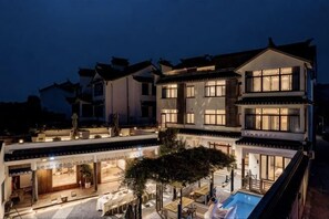 A multi-story building with a courtyard, outdoor seating, and a swimming pool. - Suzhou Taihu Lakeside·Shanhu Yin·Holiday Homestay (Suzhou)
