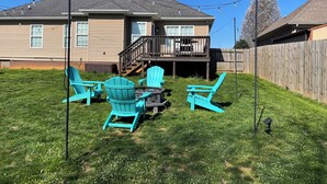 A backyard with a patio set and a wooden deck. - Vette City retreat convenient to Mammoth Caves, Beech Bend, NCM, WKU. (Bowling Green)