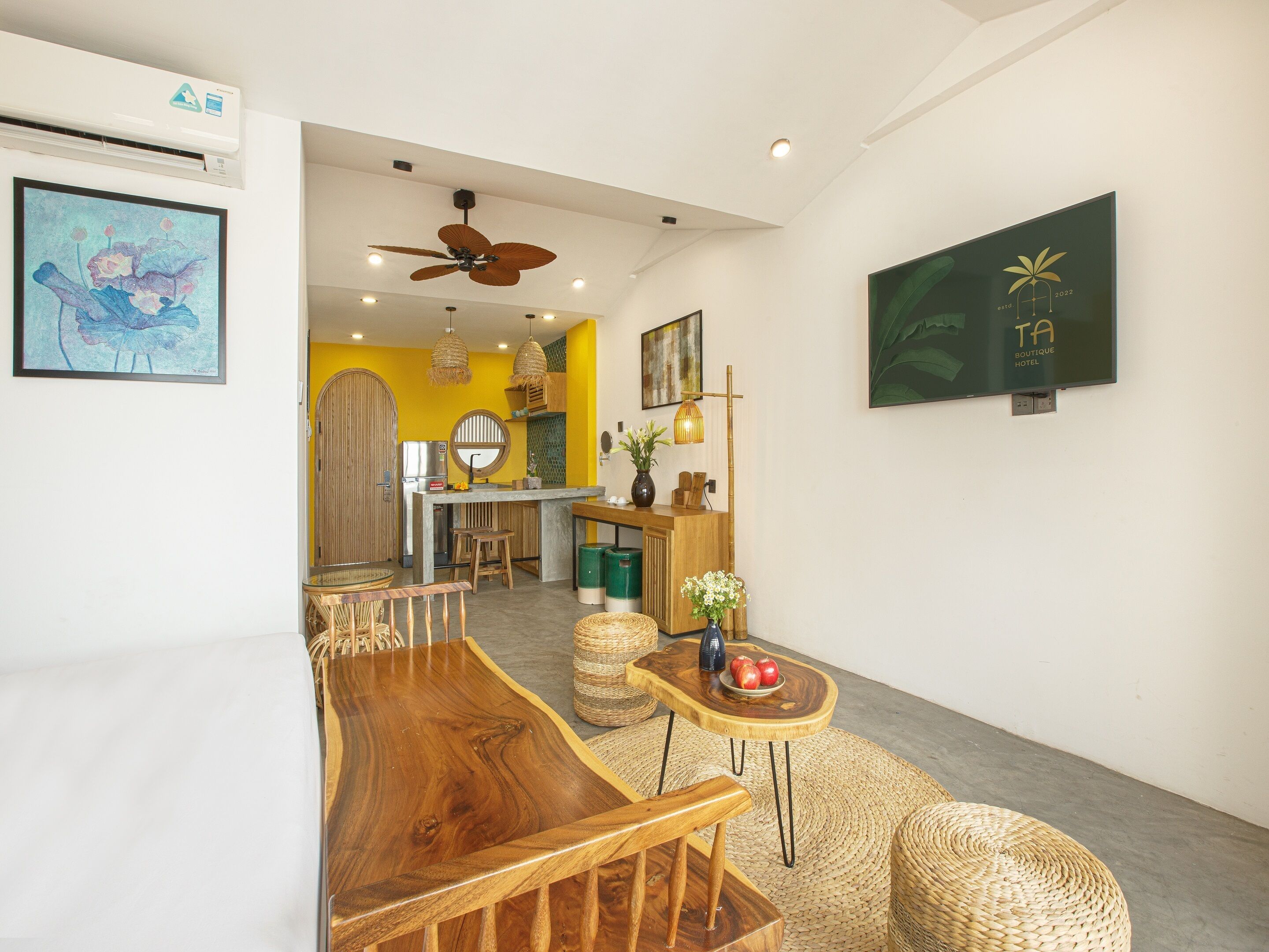 A modern hotel lobby with a reception desk, seating area, and artwork on the walls.