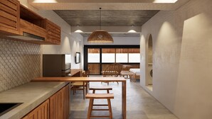 Een moderne keuken met houten kastjes, een inbouwkoelkast en een eethoek met een houten tafel en stoelen.