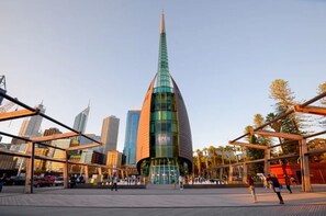 A modern building with a curved glass facade and a sign that reads "OPEN". - Prime 2BR Suite on Mounts Bay Road (Perth)