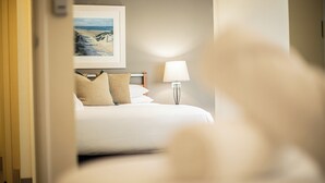 A hotel room with a bed, pillows, a nightstand, a lamp, and a framed picture on the wall. - Prime 2BR Suite on Mounts Bay Road (Perth)