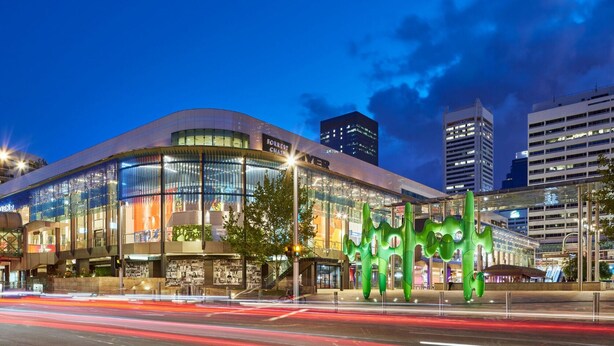 A modern building with a curved facade, large glass windows, and a prominent green sculpture in front. - Prime 2BR Suite on Mounts Bay Road (Perth)