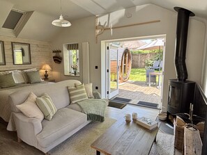 Een gezellige slaapkamer met een bed, een sofa, een tafel met mokken, een open haard en uitzicht op de omgeving.