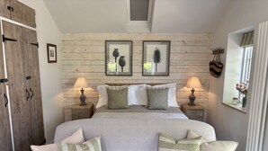 A bedroom with a bed, two bedside tables, a wooden wardrobe, and a window with curtains. - Drovers Run - Beaminster, Dorset (Chard)